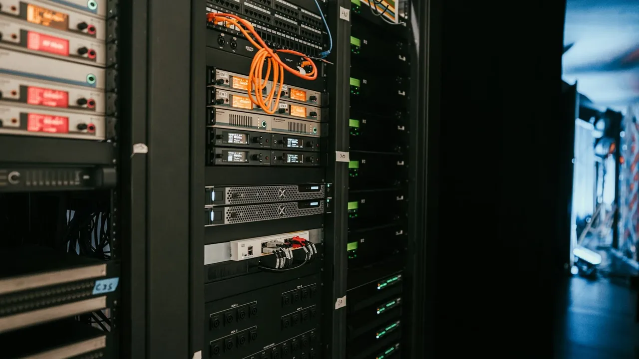 Rack de equipamentos de rede com cabos laranja e azul conectados