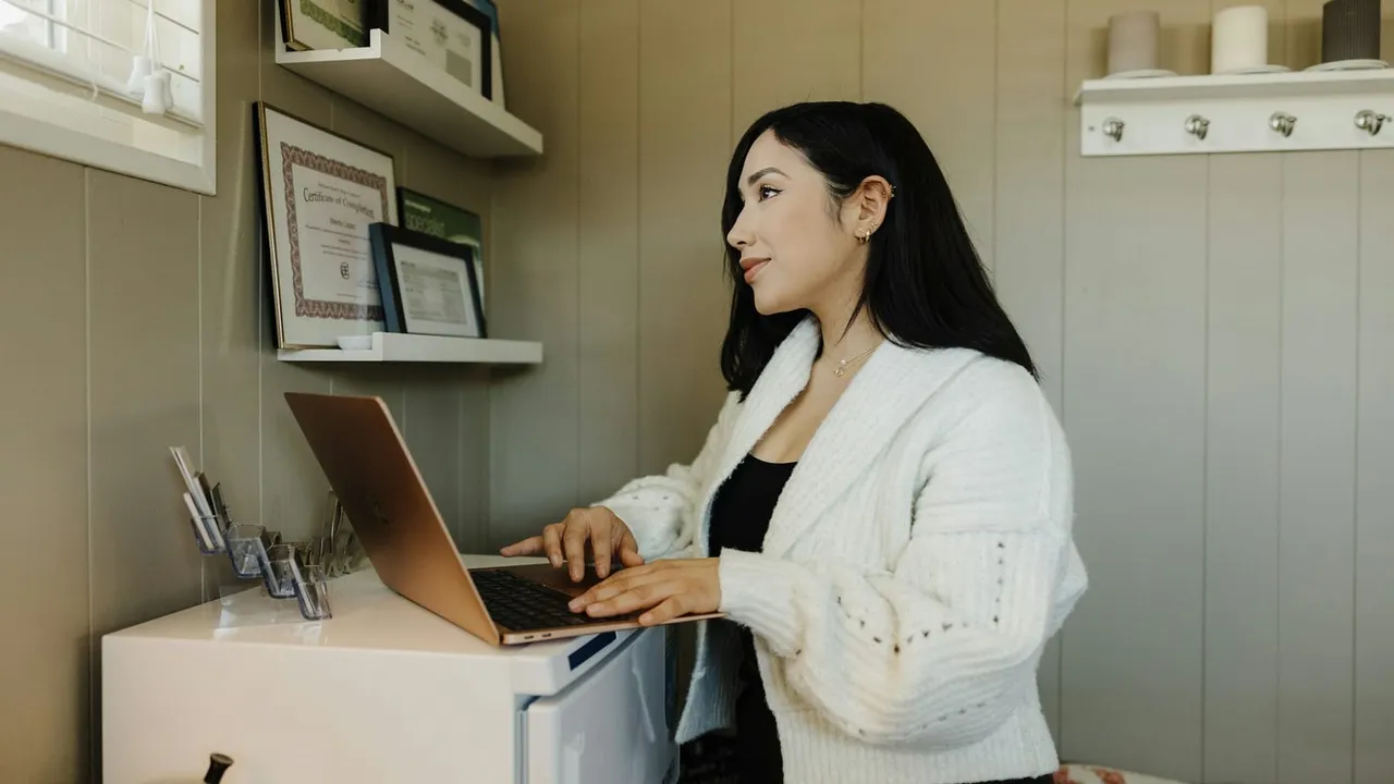 Empreendedora trabalha no notebook em seu escritório